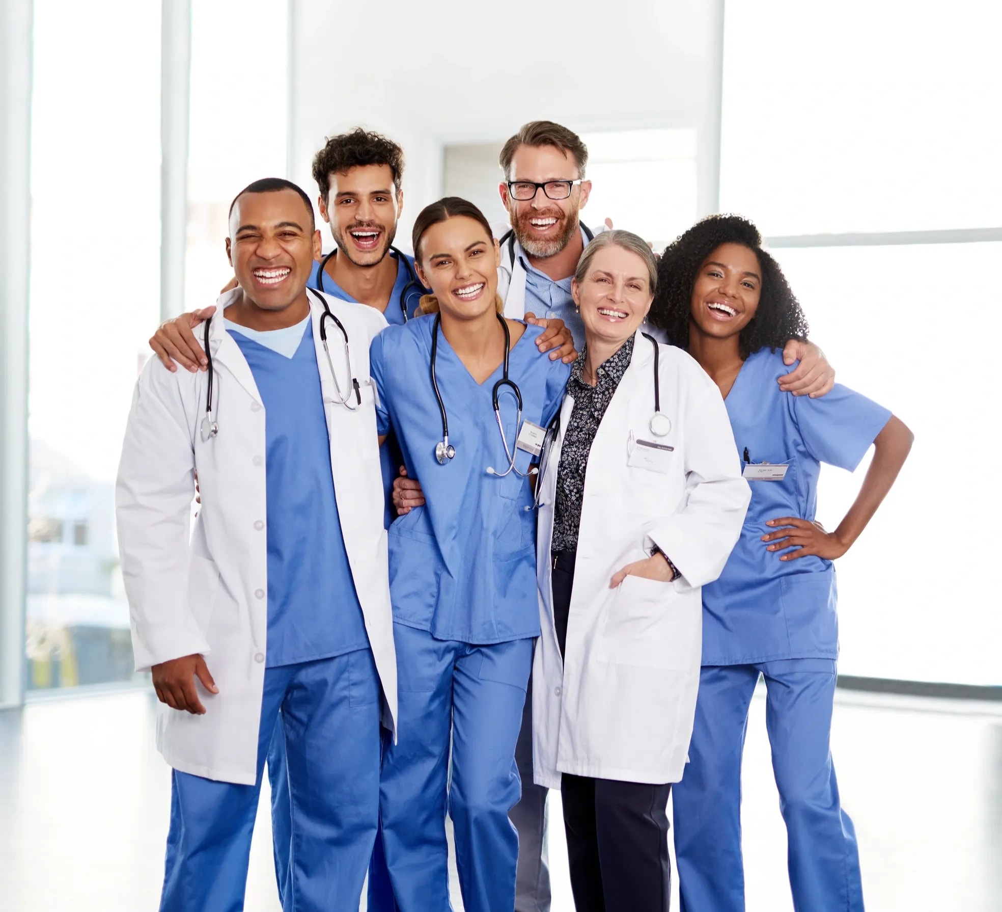 Small group of medical providers in white lab coats smiling together